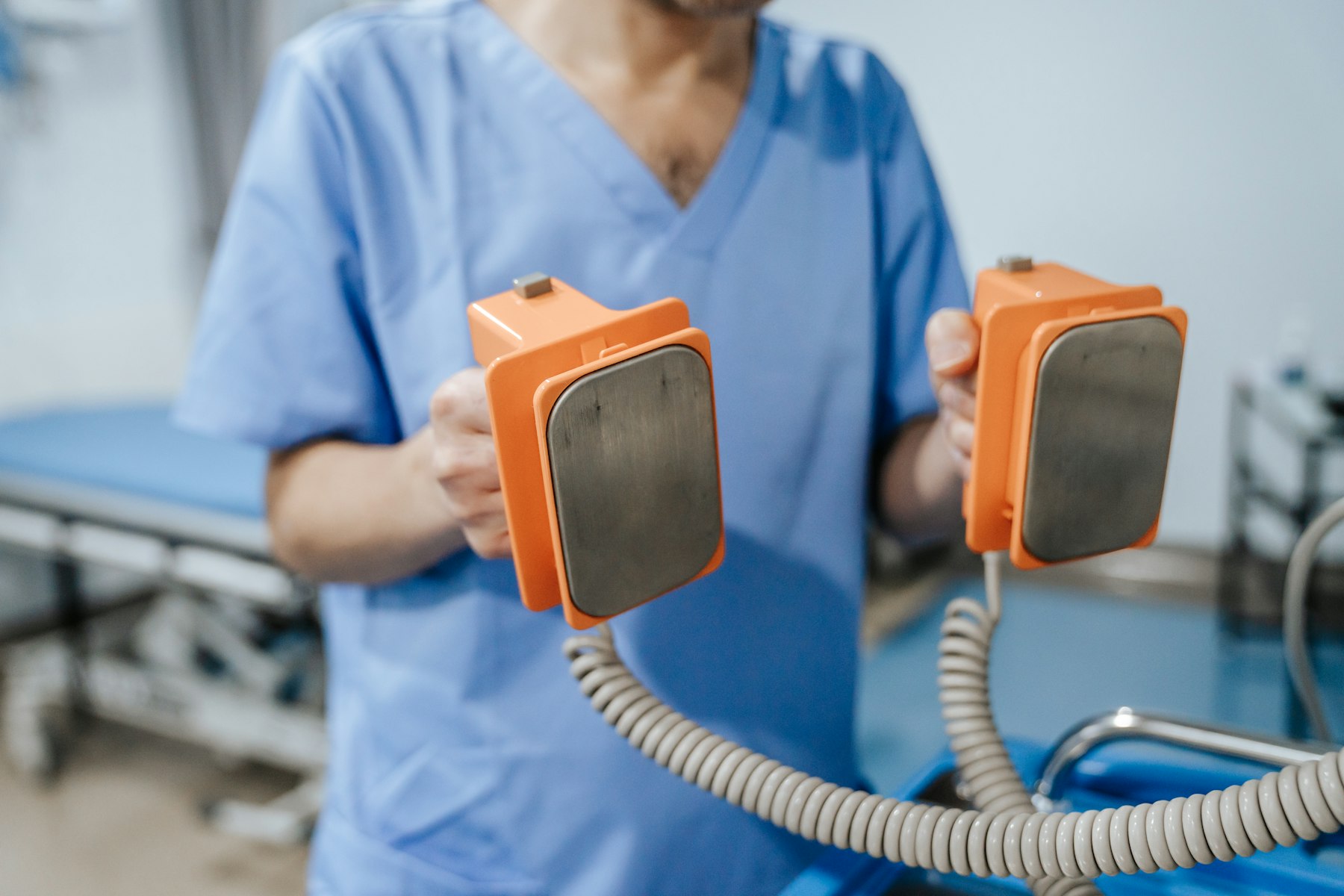 Clinician holding defibrillator paddles used for electrical cardioversion