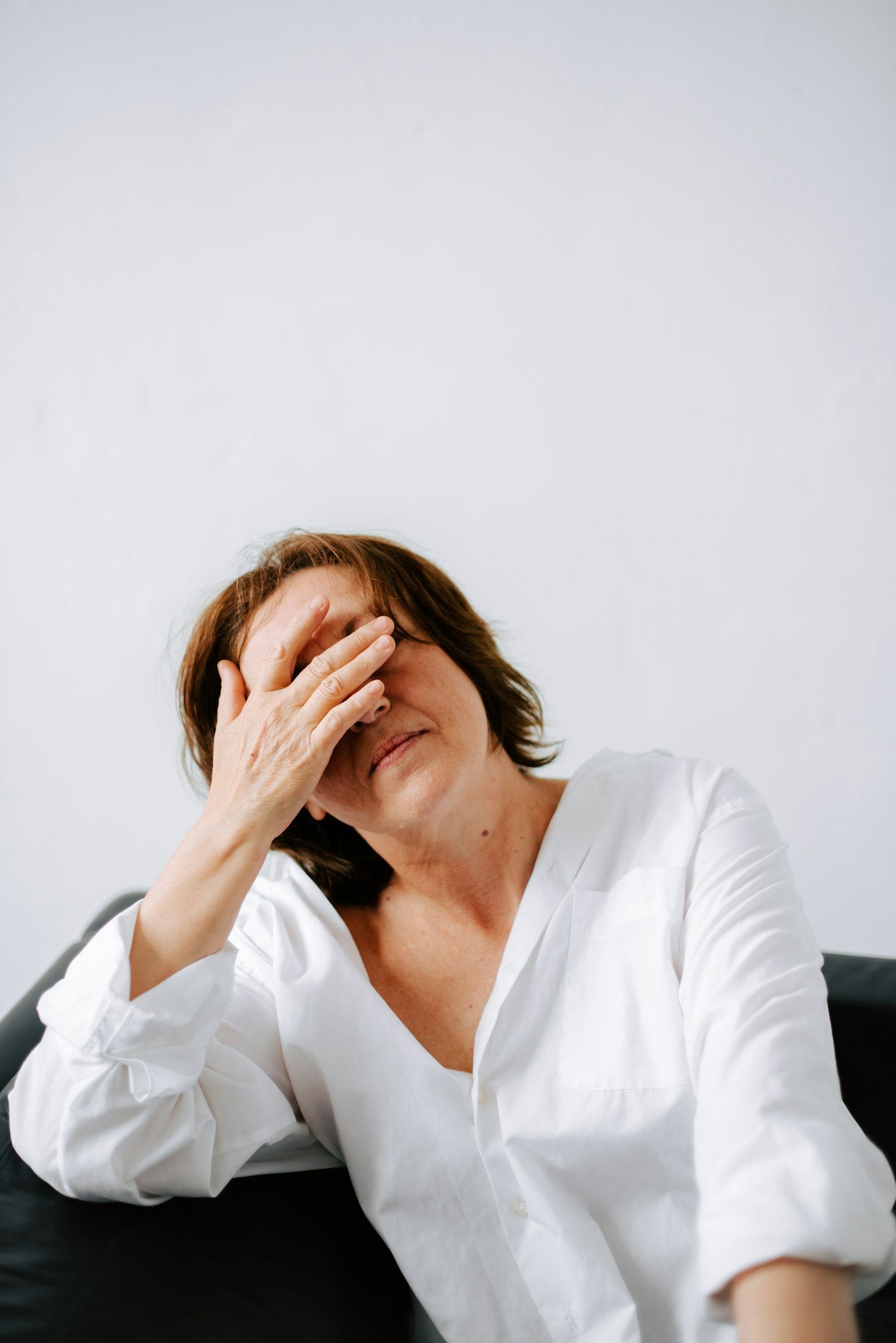 Older woman holding her hand to her face, feeling unusually tired and unwell